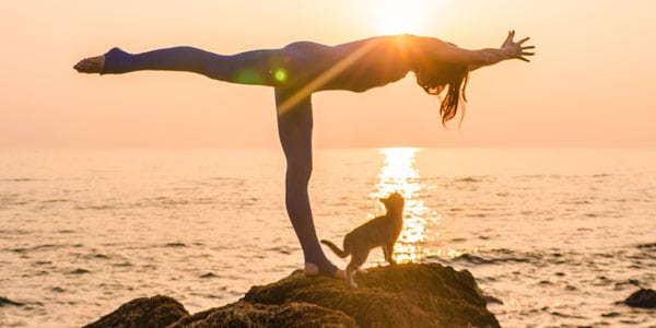 Woman in yoga pose beside the ocean